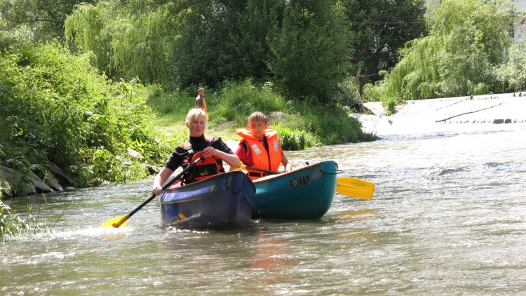 Frau und Kind in einem Kanu, beide tragen Rettungswesten